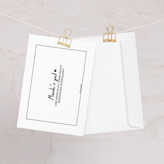 Eine weiße "Mach's gut." Abschiedskarte von ohmycard mit schwarzem Text ist mit goldenen Heftklammern an einer Schnur befestigt, die neben einem passenden Umschlag auf einem hellen, strukturierten Hintergrund liegt.