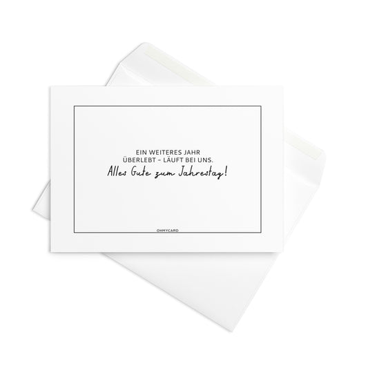 Die ohmycard-Karte "Wieder ein Jahr überlebt." zeigt humorvoll den Spruch "Ein weiteres Jahr überlebt - läuft bei uns. Alles Gute zum Jahrestag!" und wird mit passendem weißem Umschlag geliefert.