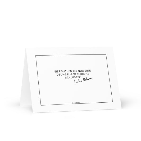 Die ohmycard "Übung für verlorene Schlüssel" Osterkarte zeigt schwarzen deutschen Text auf weiß: "Eier suchen ist nur eine Übung für verlorene Schlüssel! Frohe Ostern." Eine humorvolle Karte, die perfekt zu Ostern passt. Sie ist aufrecht stehend auf weißem Hintergrund abgebildet.