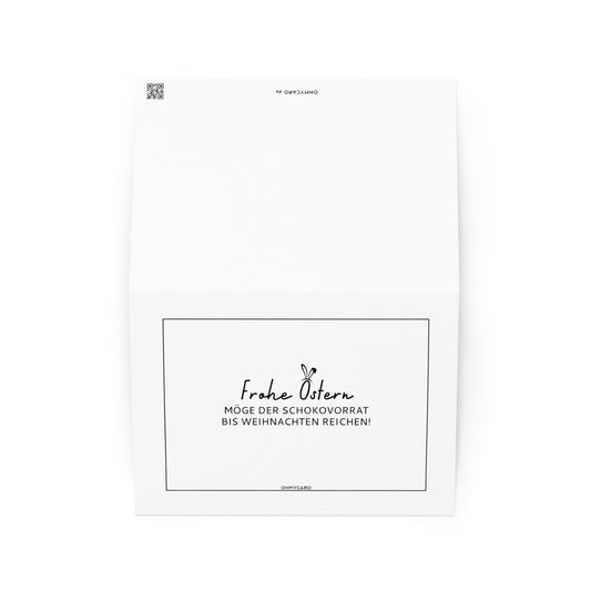 Die ohmycard Schokovorrat ist eine weiße Schokoladenkarte mit der Aufschrift "Frohe Ostern. Möge der Schokovorrat bis Weihnachten reichen!" in schwarzer Schrift, zentriert auf der unteren Hälfte - idealerweise als Ostergeschenk. Steht aufrecht vor einem weißen Hintergrund.