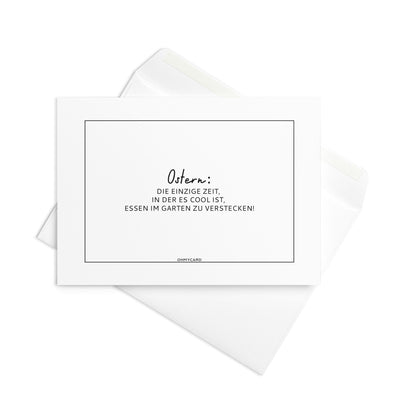 Eine weiße "An Ostern kann man Essen verstecken" Osterkarte von ohmycard mit deutschem Text auf passendem Umschlag - perfekt für die Ostereiersuche im Garten oder als Schokoladenversteck.