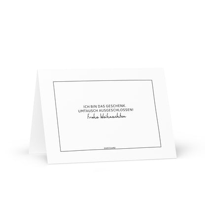Die freche Weihnachtskarte "Ich bin das Geschenk" von ohmycard überzeugt mit weißem Design, schwarzem Rand und dem deutschen Spruch: ICH BIN DAS GESCHENK. UMTAUSCH AUSGESCHLOSSEN! - ideal für witzige Weihnachtsgrüße.