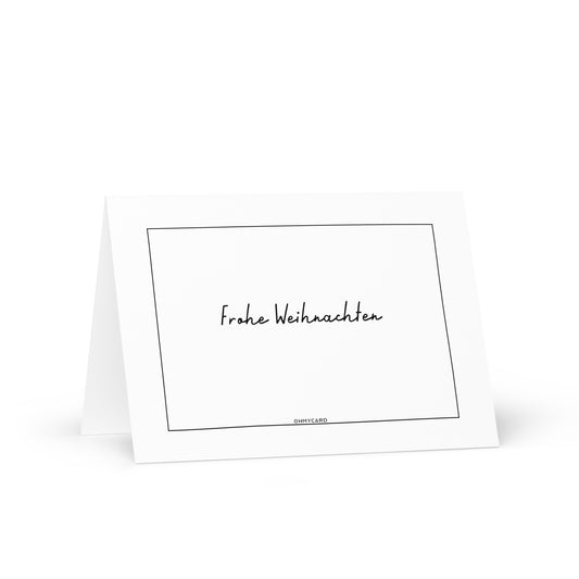 Die minimalistische Grußkarte "Frohe Weihnachten" von ohmycard steht aufrecht, zeigt einen schwarzen handgeschriebenen Schriftzug und feinen Rand. Jede Karte enthält kostenlos einen Umschlag.