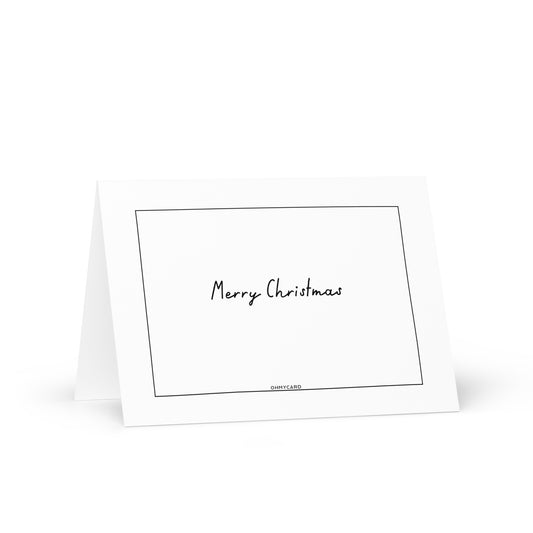 Die ohmycard Frohe-Weihnachtskarte zeigt einen schlichten, schwarzen, handgeschriebenen Text auf weißem Grund, umrahmt von einem dünnen schwarzen Rechteck. Diese elegante Karte steht aufrecht und bietet stilvolle Weihnachtsgrüße.