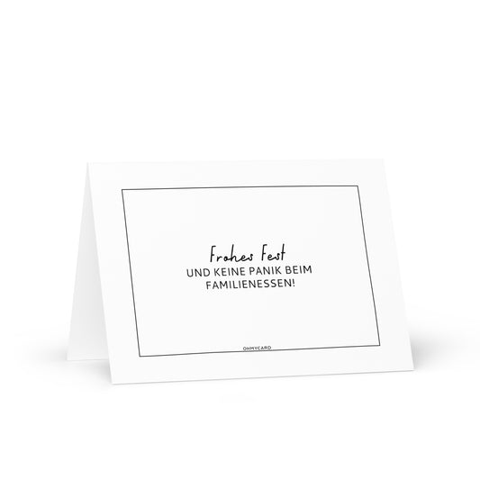 Die Grußkarte "Keine Panik beim Familienessen" von ohmycard zeigt auf weißem Karton schwarzen deutschen Text: "Frohes Fest und keine Panik beim Familienessen!" vor weißem Hintergrund.