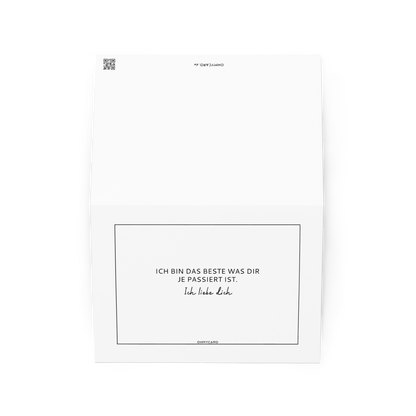 Die weiße ohmycard Grußkarte "Das Beste" zeigt den schwarzen Text: ICH BIN DAS BESTE WAS DIR JE PASSIERT IST. Ich liebe Dich. - die perfekte Liebeskarte für Beziehungen, aufrecht und leicht geöffnet vor schlichtem Hintergrund.